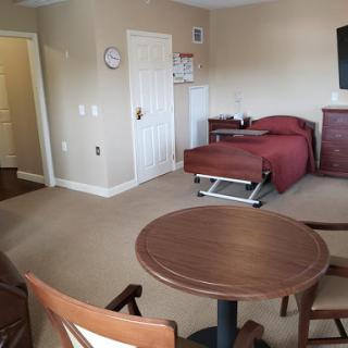 A cozy room featuring a bed, table, and chairs.