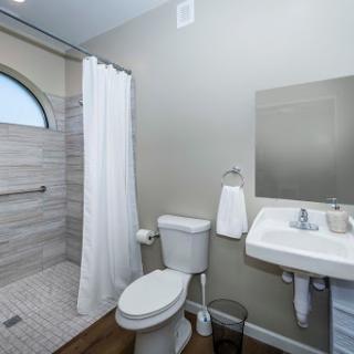 A modern and clean bathroom featuring a shower, toilet, and sink.