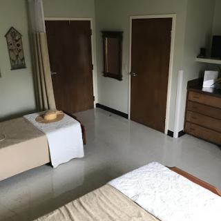 A cozy and simple bedroom featuring two beds, wooden doors, and minimal decor.