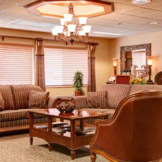 A cozy and elegant living room featuring comfortable sofas, a stylish coffee table, and a decorative chandelier.