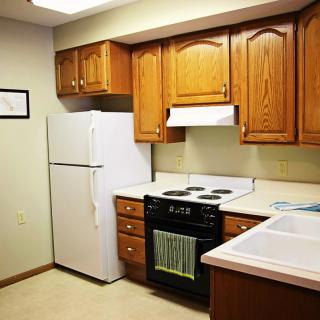 A cozy kitchen with wooden cabinets and standard appliances.