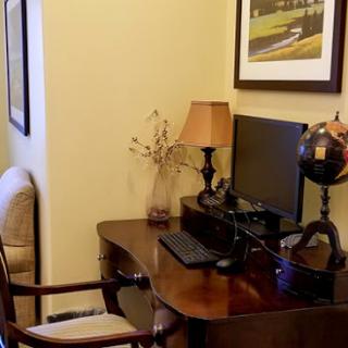 A cozy home office setup featuring a desk with a computer, lamp, and decorative globe.