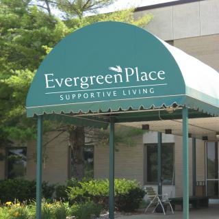 Entrance to Evergreen Place Supportive Living with a green awning.