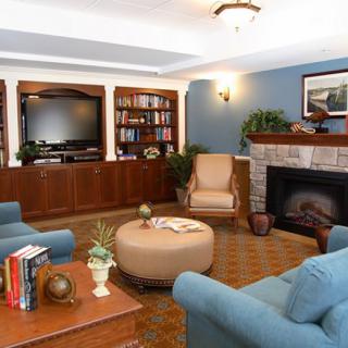 A cozy living room with a television, bookshelves, and a fireplace.