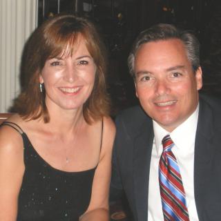 A smiling couple dressed in formal attire.