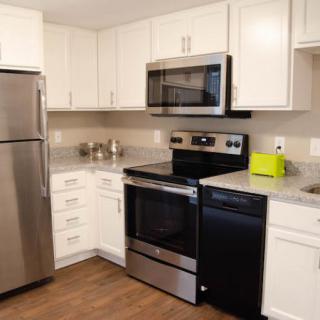 A modern kitchen with stainless steel appliances and white cabinets.