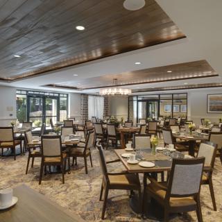 A spacious and elegantly designed dining area with neatly arranged tables and chairs.