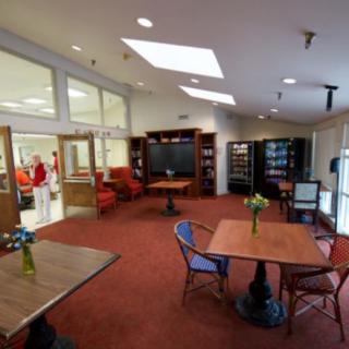 A lounge area with tables, chairs, and vending machines.