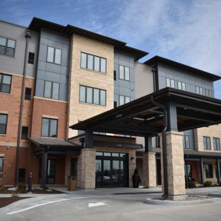 A modern building with mixed materials and a covered entrance.