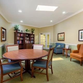 A cozy living room with a round table, chairs, bookshelves, and comfortable seating.