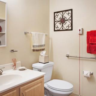A modern bathroom with a toilet, sink, and decorative wall art.