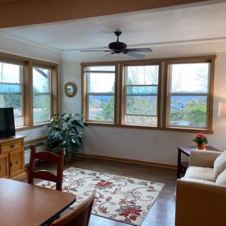 A cozy living room with large windows and comfortable furnishings.