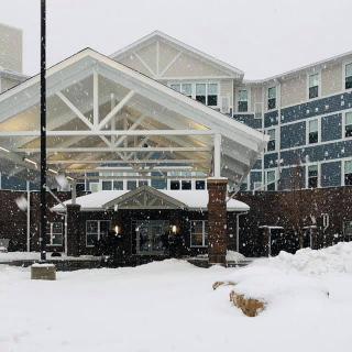 A snowy winter day at the entrance of a hotel.