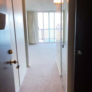 View from a hallway leading to a bright room with a balcony.