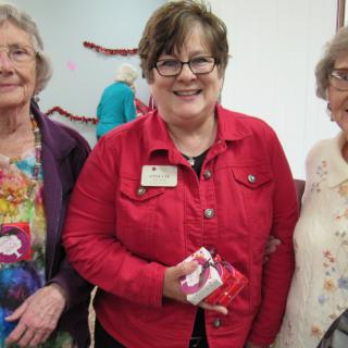 A group of women smiling at an indoor gathering.
