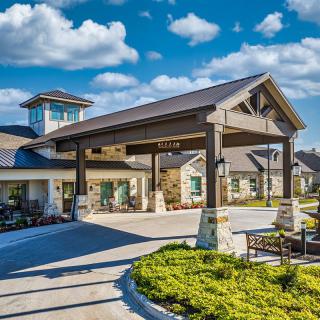 A modern building entrance with landscaped surroundings under a bright sky.