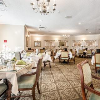 Elegant dining room with neatly arranged tables and a chandelier.