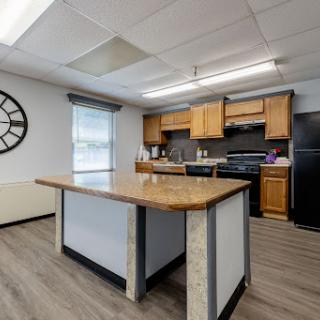 A modern kitchen featuring wooden cabinets, a spacious island, and contemporary appliances.