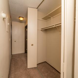 An empty hallway leading to a spacious closet.
