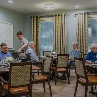Residents enjoying a meal in a care facility's dining room.