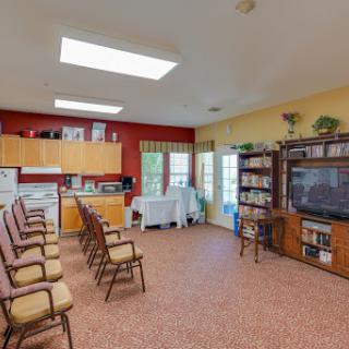 A cozy communal space featuring a kitchen area, seating for gatherings, and ample natural light.