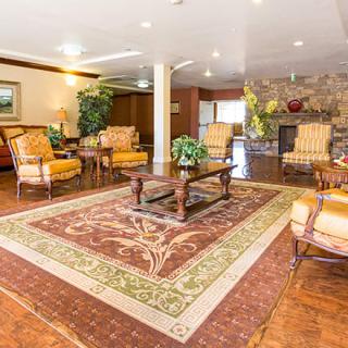 A spacious living room with elegant furniture and a large decorative rug.