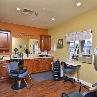 A brightly lit salon interior with chairs, mirrors, and hair styling equipment.