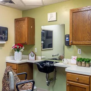 A cozy salon interior with a sink, mirror, and cabinets.