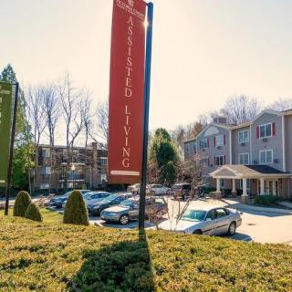 An assisted living facility with a parking lot on a sunny day.