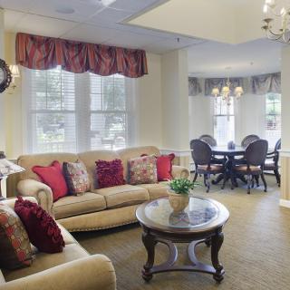 A cozy living room with a sofa, coffee table, and adjacent dining area.