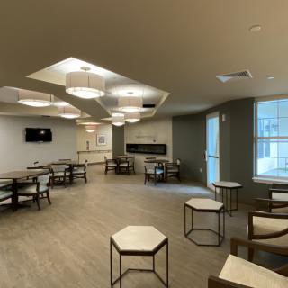 A modern lounge area with tables, chairs, and contemporary lighting fixtures.