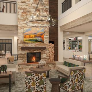 A modern hotel lobby with a cozy fireplace and stylish furniture.