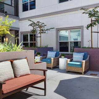 A modern patio area with comfortable seating and lush greenery.