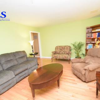 A cozy living room with comfortable seating and a bookshelf.