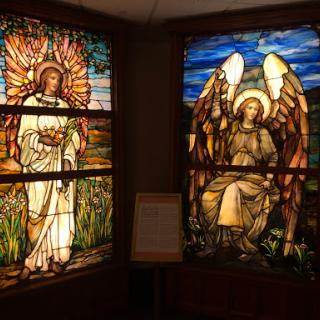 Beautiful stained glass windows depicting angelic figures and nature.