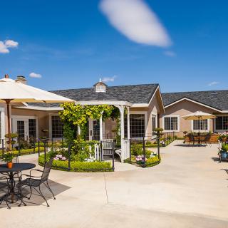 A peaceful courtyard with seating under a sunny blue sky.