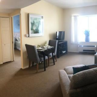 A cozy living room with a dining area, sofa, and television.