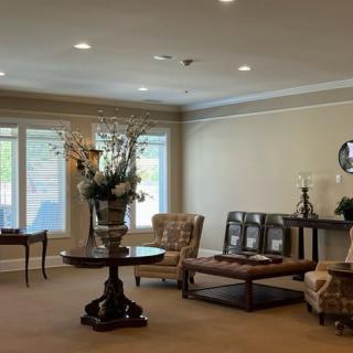 A well-decorated lobby area featuring elegant furniture and a floral centerpiece on a round table.