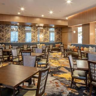 A spacious restaurant interior featuring multiple tables and chairs with elegant decor.