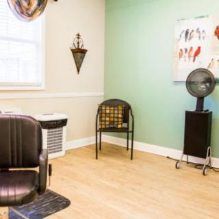 A cozy hair salon room with styling chair and wall decorations.