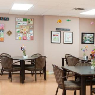 A cozy dining area with tables, chairs, and decorative wall art.