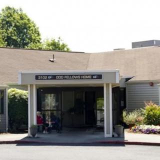 The image shows the entrance to a healthcare clinic surrounded by greenery.