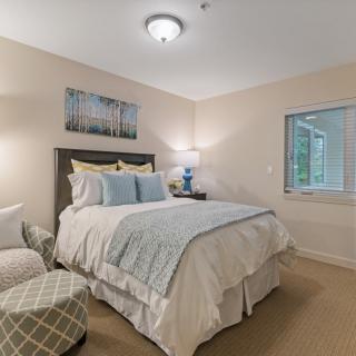 A cozy and well-decorated bedroom with a neatly made bed and stylish decor.