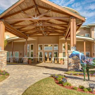 A welcoming building entrance with a covered walkway and landscaped surroundings.