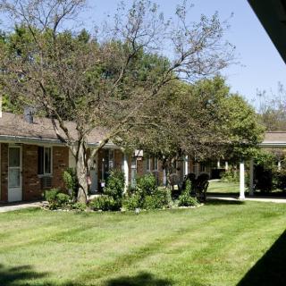 A sunny day at a residential building surrounded by trees and well-maintained lawns.