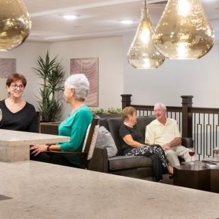 A group of people enjoying a conversation in a warmly lit indoor setting.