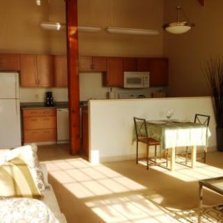A sunlit apartment kitchen and dining area with modern furnishings.