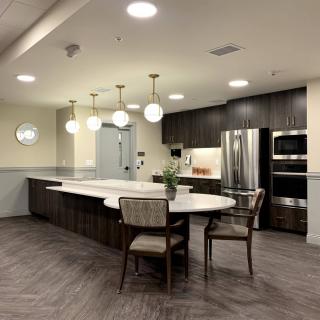 A modern kitchen with sleek design, featuring elegant lighting and stainless steel appliances.