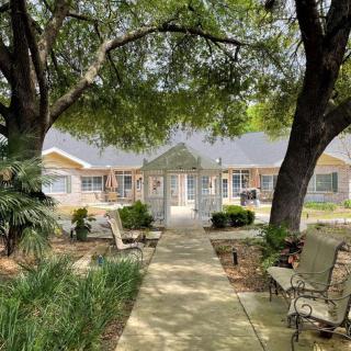 A tranquil house surrounded by lush greenery, featuring a pathway and outdoor seating.