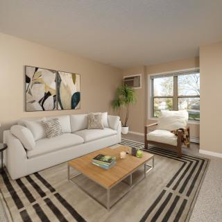A cozy living room with a white sofa, stylish artwork, and a wooden coffee table on a striped rug.